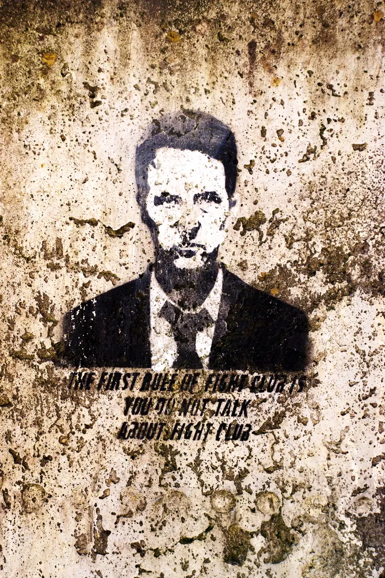 Fight Club ending explained: a stencilled portrait painted above the first rule of Fight Club on a wall in Poland